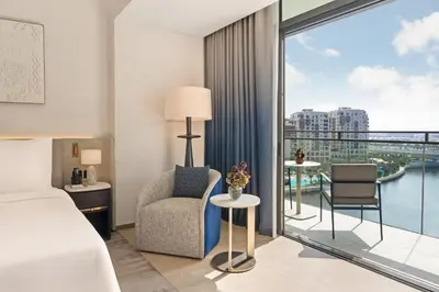a bedroom with a bed and a balcony with a view at Palace Dubai Creek Harbour in Dubai