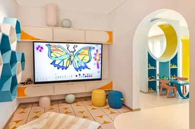 a living room with a tv with a butterfly on the screen at Palace Dubai Creek Harbour in Dubai