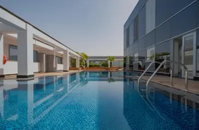 a swimming pool in front of a building at Nasma Luxury Stays - Elegant 1BR With Stunning View of Park Avenue in Dubai