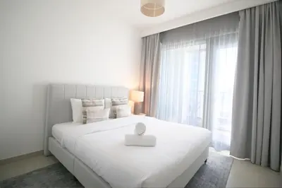 a white bedroom with a bed with a white box on it at RH - Beautiful Burj Khalifa View, 03BR with Maid's Room, 7 mins walk to Dubai Mall in Dubai
