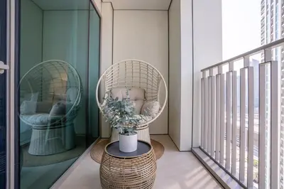 a balcony with two chairs and a table with a plant at RH - Beautiful Burj Khalifa View, 03BR with Maid's Room, 7 mins walk to Dubai Mall in Dubai