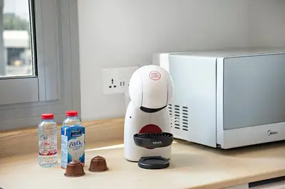a white blender sitting on a counter next to a microwave at Cozy Dubai Marina Design Studio close to Jumeirah Beach, Mall & Metro in Dubai