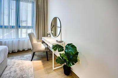 a bedroom with a mirror and a desk with a plant at Splendid brand new 1BD apartment near the beach in Dubai