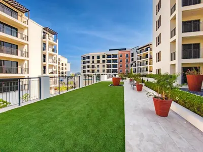 an apartment balcony with a green lawn at Splendid brand new 1BD apartment near the beach in Dubai