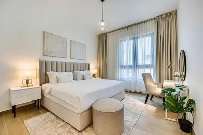 a bedroom with a large white bed and a chair at Splendid brand new 1BD apartment near the beach in Dubai