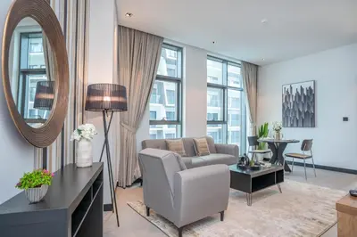a living room with a couch and a mirror at Pristine 1 Bedroom - Business Bay in Dubai