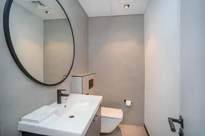 a bathroom with a sink and a mirror and a toilet at Pristine 1 Bedroom - Business Bay in Dubai