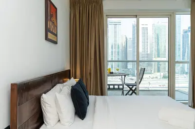 a bedroom with a bed and a large window with a view at Comfortable 2 Bed - Near Marina Mall in Dubai