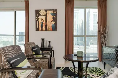 a living room with a table and chairs at Comfortable 2 Bed - Near Marina Mall in Dubai