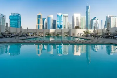 a swimming pool with a city skyline in the background at Comfortable 2 Bed - Near Marina Mall in Dubai