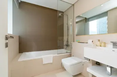 a bathroom with a tub and a toilet and a sink at Comfortable 2 Bed - Near Marina Mall in Dubai