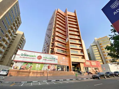 a tall building on a city street with cars at Silkhaus New studio in Silicon Oasis ASB Tower in Dubai