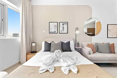 a white bedroom with a white bed and a couch at Silkhaus New studio in Silicon Oasis ASB Tower in Dubai