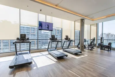 a gym with several treadmills and a flat screen tv at STAY BY LATINEM Luxury 1BR Holiday Home W 2709 Near Burj Khalifa in Dubai