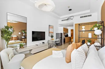 a living room with a white couch and a tv at Silkhaus New Studio in ASB Tower Walking distance to mall in Dubai