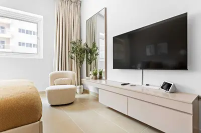 a living room with a tv on a white wall at Silkhaus New Studio in ASB Tower Walking distance to mall in Dubai