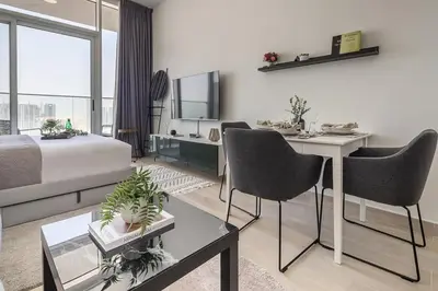 a living room with a couch and a table and chairs at Frank Porter - Bloom Heights in Dubai