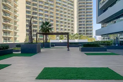 ailion in a courtyard in a city with tall buildings at Frank Porter - Bloom Heights in Dubai