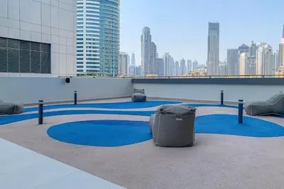 a room with blue carpeting in a building with a city at Frank Porter - The Sterling by Omniyat in Dubai