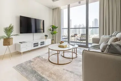 a living room with a tv and a couch and a table at Frank Porter - The Sterling by Omniyat in Dubai