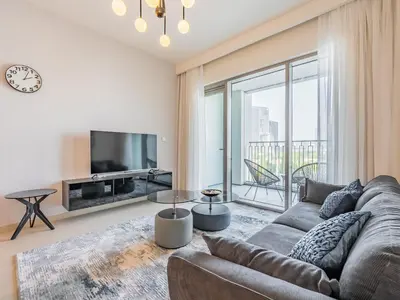 a living room with a couch and a tv at Blazing 1Br in Downtown Views in Dubai