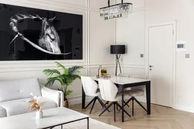 a living room with a table and a picture of a horse at Luxury 1 bedroom with beautiful marina view! in Dubai