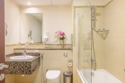 a bathroom with a sink and a shower and a toilet at Roda Amwaj Suites Jumeirah Beach Residence in Dubai