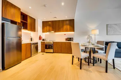 a kitchen and dining room with a table and a refrigerator at Amazing 1 bedroom in Port De La Mer near the sea in Dubai