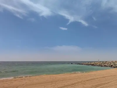 a beach with a rocky shoreline and the ocean at Amazing 1 bedroom in Port De La Mer near the sea in Dubai