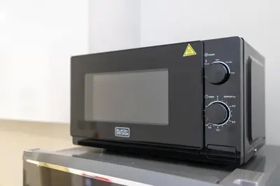 a microwave oven sitting on top of a counter at Bloom Height - Amazing Pool - Good Wi-Fi in Dubai