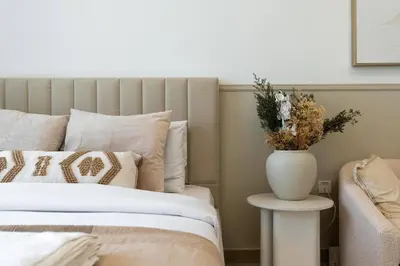 a bedroom with a bed with a vase on a table at Bloom Height - Amazing Pool - Good Wi-Fi in Dubai