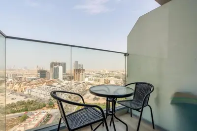 a table and two chairs on a balcony with a view at Bloom Height - Amazing Pool - Good Wi-Fi in Dubai