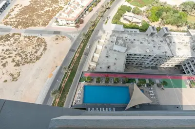 an aerial view of a building with a swimming pool at Bloom Height - Amazing Pool - Good Wi-Fi in Dubai