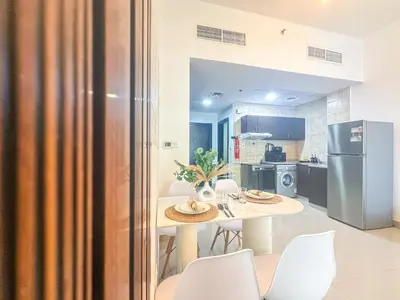 a kitchen and dining room with a table and chairs at Cool Studio near to Metro & Beach in Dubai Marina in Dubai