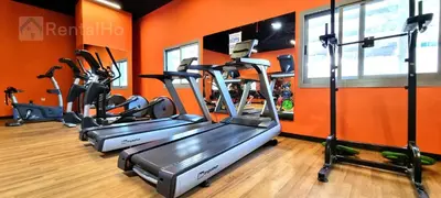 an orange gym with three tread machines in a room at Cool Studio near to Metro & Beach in Dubai Marina in Dubai