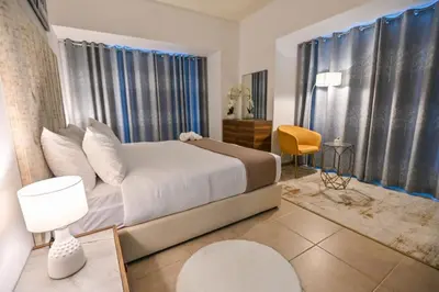 a bedroom with a white bed and a yellow chair at 54 Floor Palm & Sea View Dubai Marina. LUX / NEW in Dubai