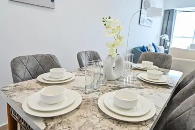 a dining room table with plates and bowls on it at 54 Floor Palm & Sea View Dubai Marina. LUX / NEW in Dubai