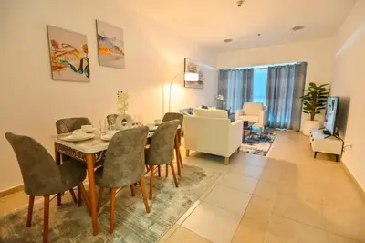 a dining room and living room with a table and chairs at 54 Floor Palm & Sea View Dubai Marina. LUX / NEW in Dubai