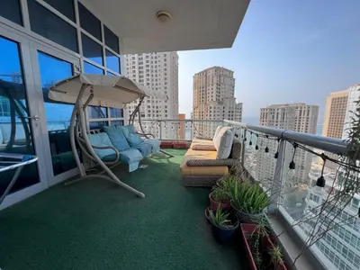 a balcony with couches and an umbrella on a building at Coliving sharing Hostel 1 in Dubai