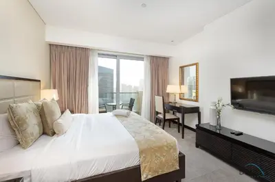 a bedroom with a bed and a desk and a television at Urban Studio at The Address Residences Dubai Marina by Deluxe Holiday Homes in Dubai