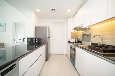 a large kitchen with white counters and stainless steel appliances at StoneTree - Furnished 2BR with floor-to-ceiling window in Dubai