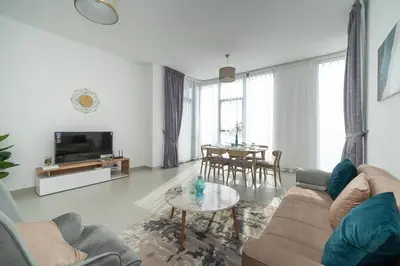 a living room with a couch and a table at StoneTree - Furnished 2BR with floor-to-ceiling window in Dubai