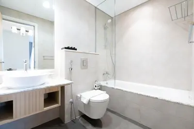 a bathroom with a sink and a toilet and a tub at Lux BnB Paramount Midtown I Ocean View in Dubai
