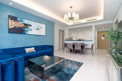 a living room with a blue couch and a table at Lux BnB Paramount Midtown I Ocean View in Dubai