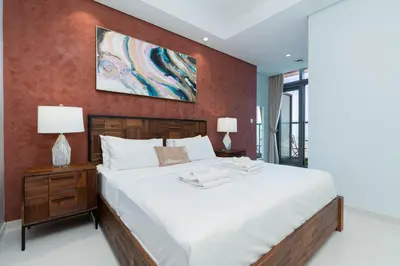 a bedroom with a large white bed and red wall at Lux BnB Paramount Midtown I Ocean View in Dubai