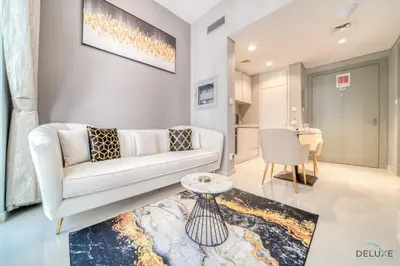 a living room with a white couch and a table at Limited Time Offer Modern 1BR at DAMAC Zada Tower by Deluxe Holiday Homes in Dubai