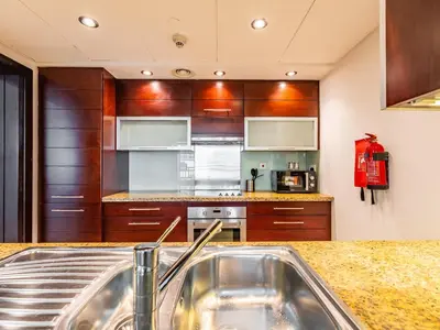 a kitchen with wooden cabinets and a kitchen sink at Incredible Studio In Burj View in Dubai