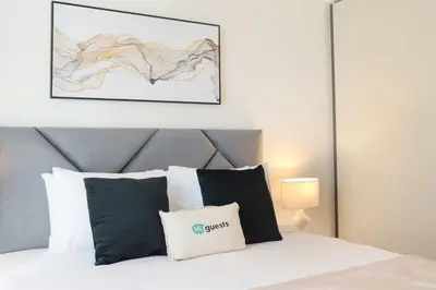 a bedroom with a white bed with black and white pillows at HiGuests - Emaar Beachfront Haven with Majestic Marina Views in Dubai