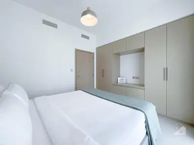 a white bedroom with a white bed and cabinets at Incredible stay at Burj Royale Downtown in Dubai