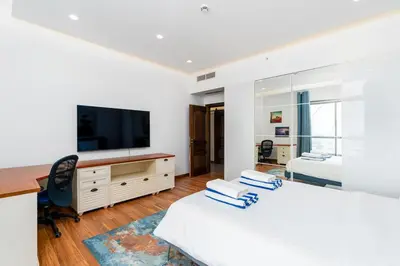 a bedroom with a bed and a desk and a television at JBR Bahar Beach Views 4 beds - DVH Holiday Homes in Dubai
